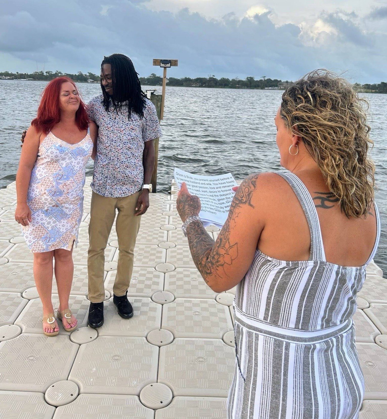 Cheryl Lucas officiating a wedding ceremony on a dock at sunset