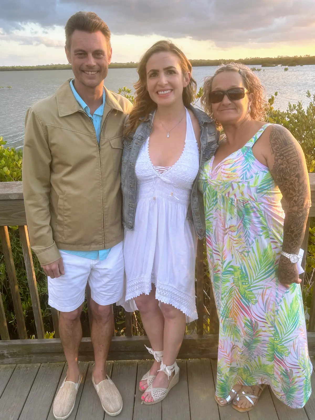 Cheryl Lucas with a couple at sunset after their ceremony