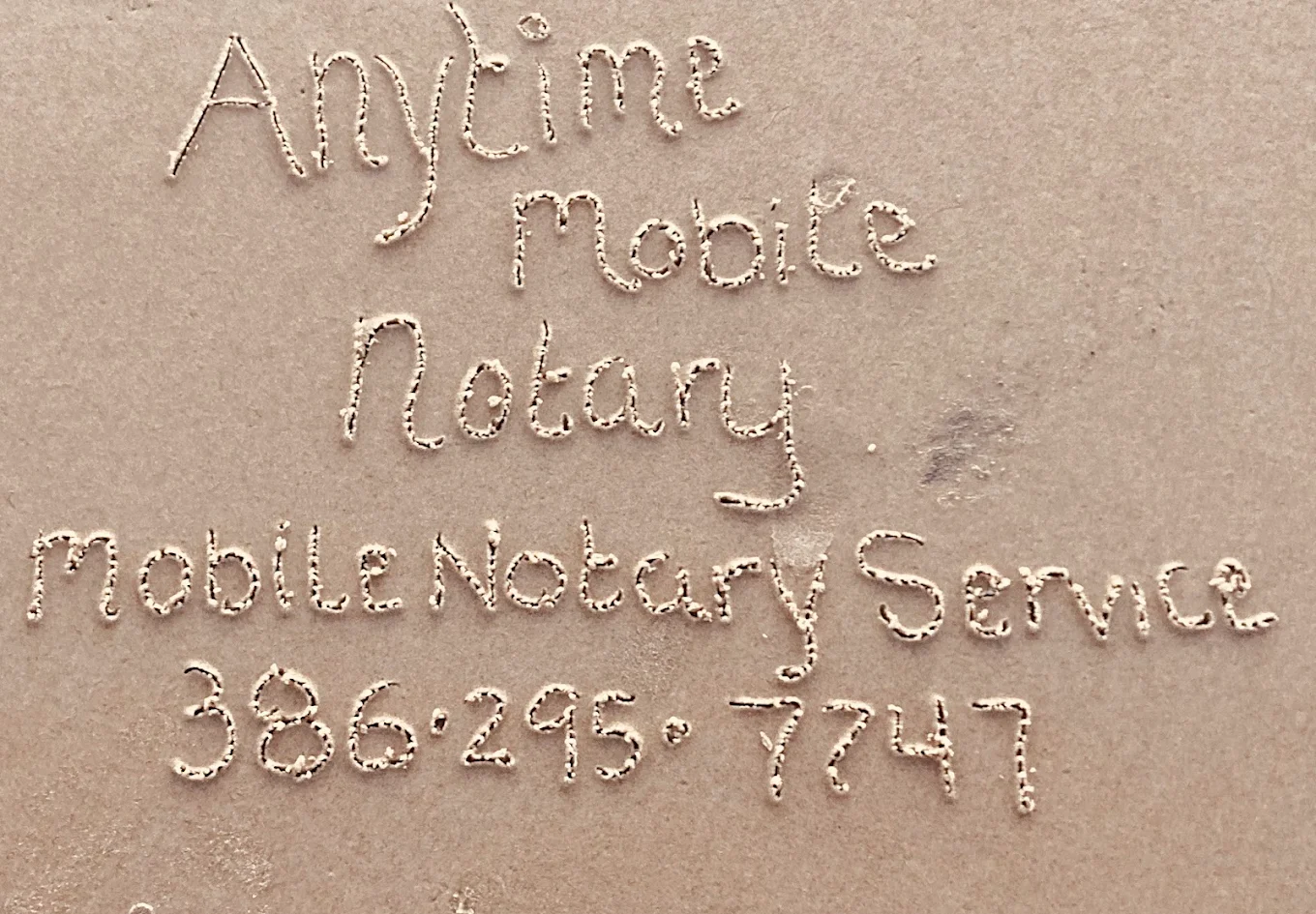 Anytime Mobile Notary and the phone number written in the sand on Daytona Beach